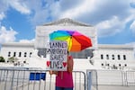 A protester stands outside of the Supreme Court, Thursday, June 26, 2025, in Washington.