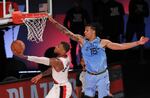 Portland Trail Blazers Damian Lillard (0) shoots the ball against Memphis Grizzlies Brandon Clarke (15) during the second half of an NBA basketball game Friday, July 31, 2020, in Lake Buena Vista, Fla.