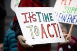 A close up of a protester's sign, which reads "It's time to act!" in bright colors.