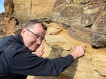 On March 14, 2023, geologist Nick Zentner points to a “moment in time” when the Ginkgo lava flowed on top of the ancient Columbia River some 16 million years ago. 