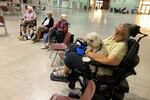 In this Sept. 8, 2020, file photo Patricia Fouts, 73, sits with her dog Murphy and other evacuated residents of a senior living home in an evacuation center at the Oregon State Fairgrounds in Salem, Ore.