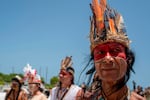 A member of the Council in Defense of the Indigenous Rights of Boriken dressed in Taínos traditional clothing sounds a conch during a march through Old San Juan, Puerto Rico, on July 11, 2020.