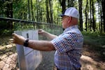 Dennis Deardorff hangs a placard on the history of Christilla Pioneer Cemetery on Aug. 27, 2025. He's a direct descendant of people buried at the 170-year-old cemetery.
