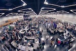 A view from the ceiling of a convention center shows dozens of people visiting booths on retro games and fandom.