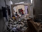 Palestinians inspect the rubble of a house after it was struck by an Israeli airstrike in Khan Younis, southern Gaza Strip, Sunday, Oct. 29, 2023.