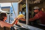 A food vendor sells a basket of fresh-cut Idaho potato fries.