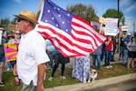 Joe Bondulich carries a flag past the crowd gathered on the side of College Street in Macon, GA. "This is the flag the last time we fought kings. This is original 13 stars and 13 stripes," Bondulich said,  "So this is the original Revolution flag."