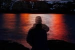 FILE - In this photo made with a long exposure, a man is silhouetted against lights reflected in the waters off Cape Neddick in Maine on Dec. 11, 2017. The FDA has rejected the use of MDMA therapy to treat PTSD. (AP Photo/Robert F. Bukaty, File)