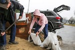 Bill and Denise Lakey fill sandbags at the Clackamas Fire Station in Milwaukie. They live next to a steep road that funnels water down their driveway and into their garage. Dec. 18, 2025