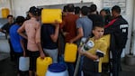 Palestinian citizens fill jugs and cans at a water station in Khan Younis, south of Gaza City, on Saturday. Gaza Strip residents are struggling with water and electricity outages due to the war between Israel and Hamas.