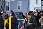 People protest as law enforcement officers attend to the scene of the shooting involving federal law enforcement agents on Wednesday in Minneapolis.