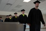 (Left to right) Sam Hannah, Chris Gonazales, Terrance Stevens, Daniel Hopkins, Tyler Boyce and Garret Bergquist process through the dining hall at the Deer Ridge Correctional Institution in Madras, Ore., on June 9, 2026. Sixteen students graduated with a welding certificate or an associates of arts Oregon transfer degree.