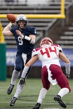 Lake Oswego quarterback Casey Filkins (9) goes to throw the ball while dodging a hit from Rams player Mason Smith (44). The Central Catholic Rams played the Lake Oswego Lakers at Hillsboro Stadium in Hillsboro, Oregon, on Dec. 7, 2019. The Rams defeated the Lakers 49-28.
