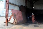 A worker at Vigor Industrial uses a wet blast technique to strip paint off a piece of ship before its is recoated with fresh paint. Vigor switched to using this technique to reduce the amount of dust and particles it emits in an effort to improve air quality for neighbors.