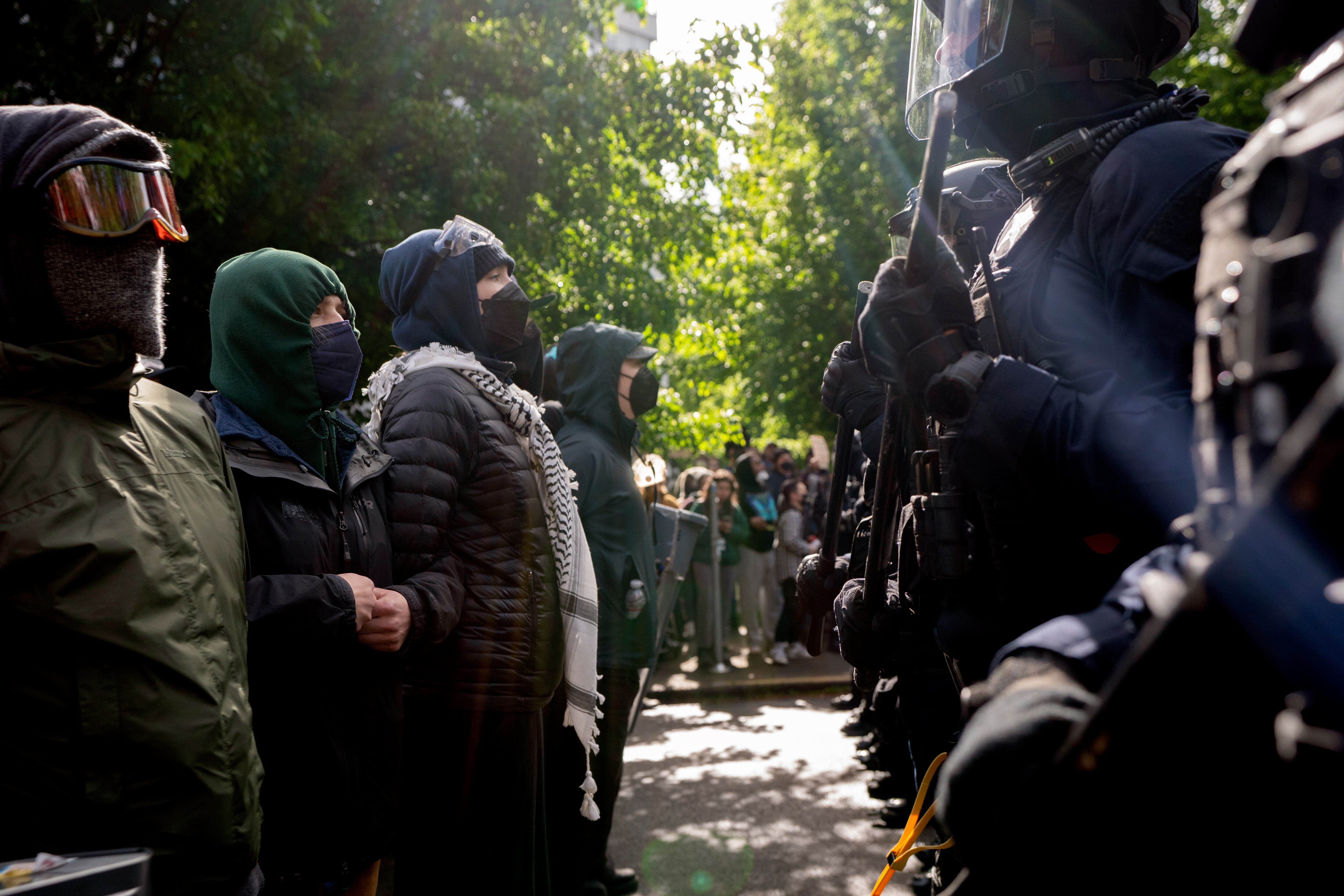 Protesters stand across from police near Portland State University’s Branford Price Millar Library, May 2, 2024. Demonstrators protesting the war in Gaza have occupied the library since Monday evening.