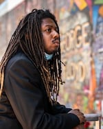 Writer, artist and producer Donovan Scribes stands in front of a mural of George Floyd painted in downtown Portland in June 2020.