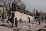 An open-air flea market where unlicensed vendors sell their wares near the railway station in Chisinau, Moldova, April 1, 2023. In the background, is a monument to the thousands of Moldovans who were deported in the 1940s and 1950s by the Stalinist-communist regime.