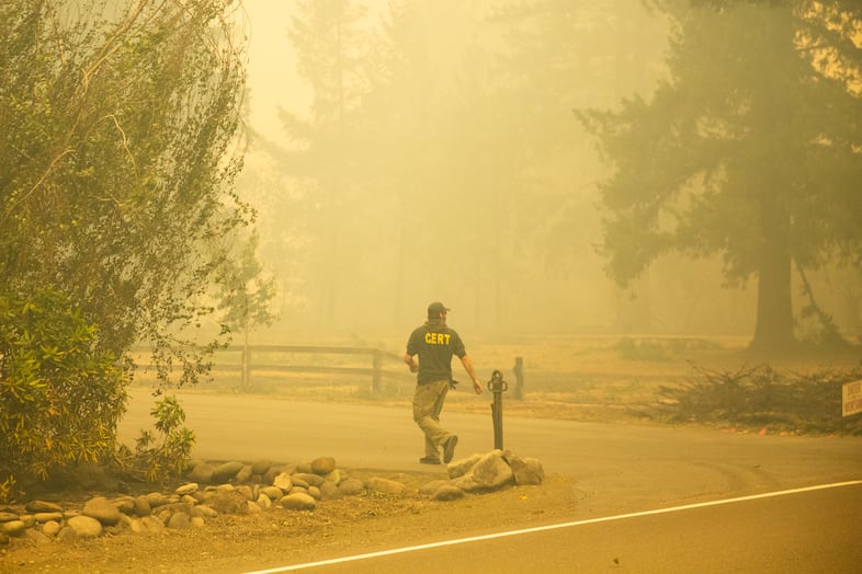 Joshua Graham heads to talk to firefighters battling the Santiam Fire near Gates, Ore., Sept. 9, 2020. Graham is part of the Citizen Emergency Response Team out of Marion County, helping people with everything from bottles of water to livestock rescues.