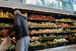 A man gathers produce from shelves of vegetables in an H-E-B grocery store in Austin, Texas, on May 11.