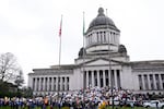 People gather to protest against the Trump administration and Project 2025 near the Washington State Capitol building Wednesday, Feb. 5, 2025, in Olympia, Wash. Federal unemployment claims in Washington state have doubled as Trump’s administration cuts federal jobs, sparking protests and legal challenges.