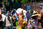 Artistas con Alma Oaxaqueña lanzan fruta a asistentes a la Guelaguetza después de su danza en Shute Park en Hillsboro, Ore., el 9 de agosto de 2025. La Guelaguetza es un evento anual que busca celebrar la cultura indígena y generar sentido de pertenencia.