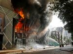 Firefighters douse a fire engulfing a shopping center which was set on fire by protesters during a rally against Prime Minister Sheikh Hasina and her government in Dhaka, Bangladesh. 