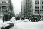 Snow removal operations at SW 6th Ave and Morrison St looking north, Portland, Ore., Jan. 4 1950. Not seen are the Pioneer Courthouse on the right and Pioneer Square on the left. The clock on the building on the left still stands.