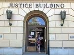 FILE - A woman enters the Oregon Department of Justice building in Salem, Ore., May 28, 2020.