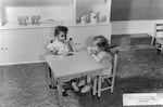 Two girls share milk and cookies at the Child Service Center on Swan Island, which provided daycare for Vanport residents.