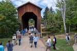 Attendees of the 2026 Buster Keaton Conference cross the Chambers Covered Railroad Bridge during a tour in Cottage Grove, Ore., on Saturday, Aug. 29, 2026. (Krista Rossow for NPR)
