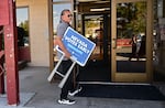 Little Buck Harjo carries 'Nevada Votes Early' signs at the reno-Sparks Indian Colony in Reno, Nev., on Oct. 15, 2024.