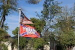 Flags in a Prineville yard combine the text of the 2nd Amendment, Confederate imagery, and political support for former President Donald Trump. The house next door has a for sale sign up on May 17, 2021.