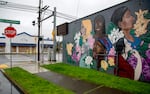 A mural on the side of a building depicting people of different ethnicities.