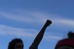 A police helicopter hovers overhead while thousands marched across Portland, Ore., and gathered at the fenced off Justice Center for a night of protests on June 3, 2020, over the killing of George Floyd, a Black man from Minneapolis who was killed after an officer pushed his knee into his neck for nearly nine minutes.