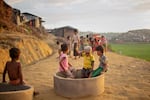 A group of children find a place to sit and play among the construction as Rohingya refugees build IDP camps outside of Cox's Bazar, Bangladesh on October 12, 2017.