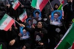 People wave Iranian flags as they hold posters of the late Supreme Leader Ayatollah Ali Khamenei, showing him at different ages, during a rally to support his son Ayatollah Mojtaba Khamenei, who succeeds his father as the new supreme leader, in Tehran, Iran.