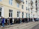 Voters queue at a polling station in Moscow on Sunday. The Russian opposition has called on people to head to polling stations at noon on Sunday in protest as voting takes place on the last day of a presidential election that is all but certain to extend President Vladimir Putin's rule after he clamped down on dissent.