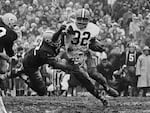In this Jan. 2, 1966, file photo, Cleveland Browns' Jim Brown (32) turns the corner as a Green Bay Packer defender swings with him during a football game in Green Bay, Wisc.