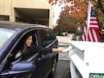 In this Nov. 6, 2018 file photo, a voter in Lake Oswego, Ore., places her ballot in a designated drop box outside City Hall. Two Oregon counties are offering the opportunity for U.S. military members, their dependents and others living overseas to vote in special elections this November with smartphones.