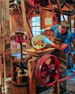 Slices of apples, dumped into a grinder, are turned into tart-sweet cider at the Cedar Creek Grist Mill.