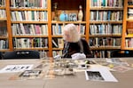 Cynthia Basye examines the archived photos of Daiichi Takeoka at the library of the Japanese American Museum of Oregon in Portland, Ore., on April 30, 2024.