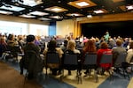 Several people gathered in an auditorium at Clark College in Vancouver to discuss recent hate incidents on campus.