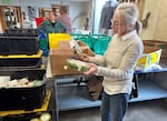 Tracy Oseran looking at salads donated to Urban Gleaners on May 22, 2023. She founded the nonprofit in 2006 to redistribute fresh foods that would otherwise go to waste to people in need.