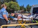 Two paramedics carry a pretend patient to an ambulance outside Oakdale Middle School during the exercise.