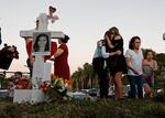 FILE - In this Feb. 18, 2018, file photo, Magaly Newcomb, right, comforts her daughter Haley Newcomb, 14, a student at Marjory Stoneman Douglas High School, at a memorial outside the school in Parkland, Fla. It’s been more than 1,000 days since a gunman with an AR-15 rifle burst into the school, killing 17 people and wounding 17 others. And yet, with Valentine’s Day on Sunday, Feb. 14, 2021, marking the three-year milestone, Nikolas Cruz’s death penalty trial is in limbo.