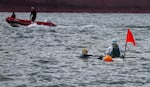 Peyton Scott pauses next to her mother Jada Scott's kayak to refuel and check in about navigation during the Swim Across the Columbia event in Astoria, Ore., Aug 11, 2024. 