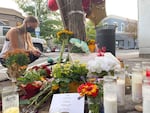 Fifteen-year-old Wrenna Laudenslager lights a candle at a memorial near where Barry Washington Jr. was killed in downtown Bend on Sept. 21, 2021.