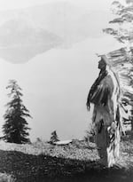 A Klamath Indian chief in a feather headdress stands on a mountain overlooking Crater Lake in 1923, long considered a sacred spot by local tribes. In 1902, the lake became a national park thanks to William Gladstone Steel, who for 17 years petitioned Congress to protect the natural wonder.
 
