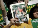 A George Mason University fan holds up the cover of Sports Illustrated magazine at a send off for the team, on March 29, 2006, in Fairfax, Va. The union representing the magazine's staff said that SI's publisher plans to cut "a significant number, possibly all" of its union-represented staff.