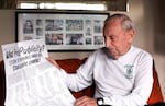 Bill McChesney looking over the full page op-ed inside his home in Eugene. 